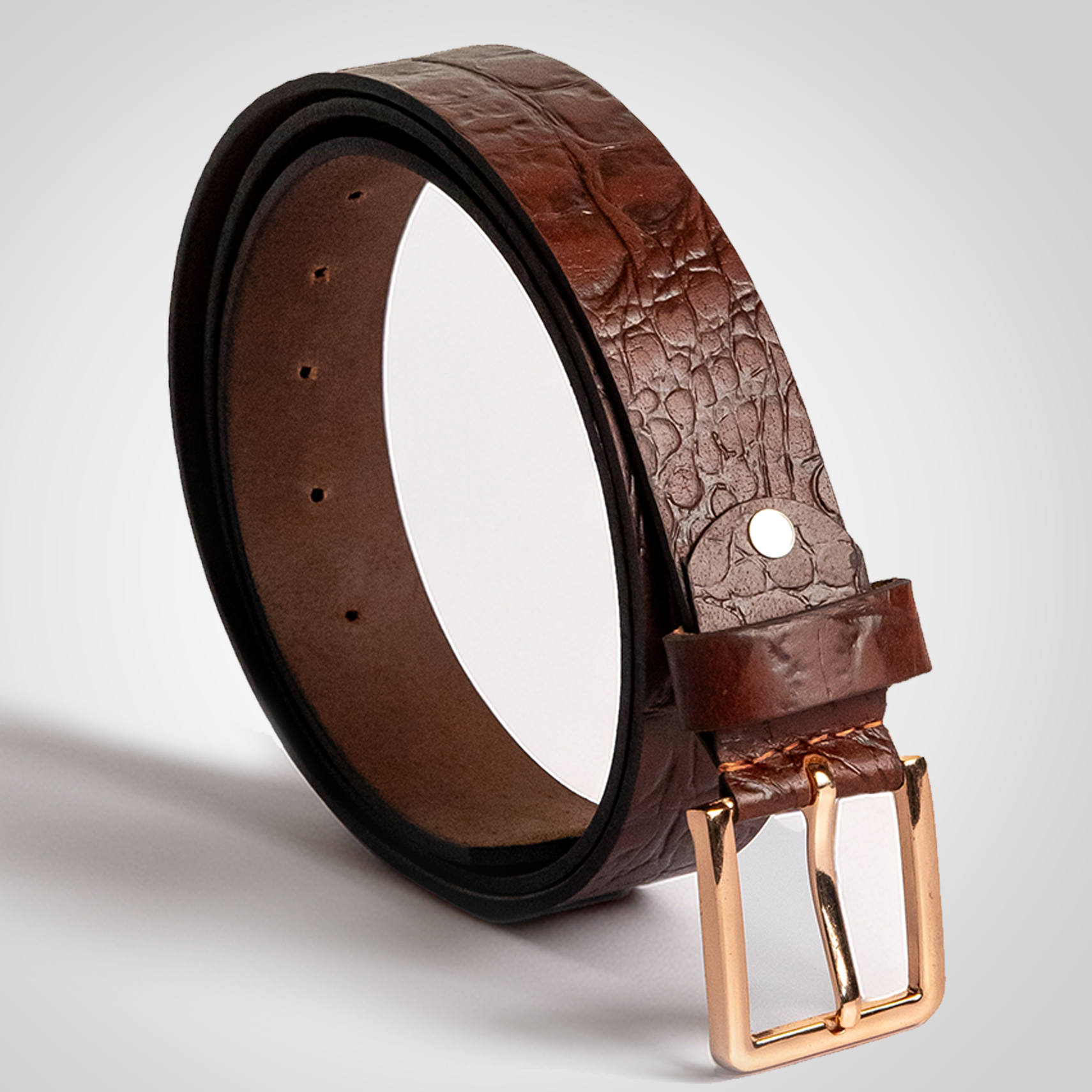 Brown embossed leather belt with a gold buckle on a light gray background
