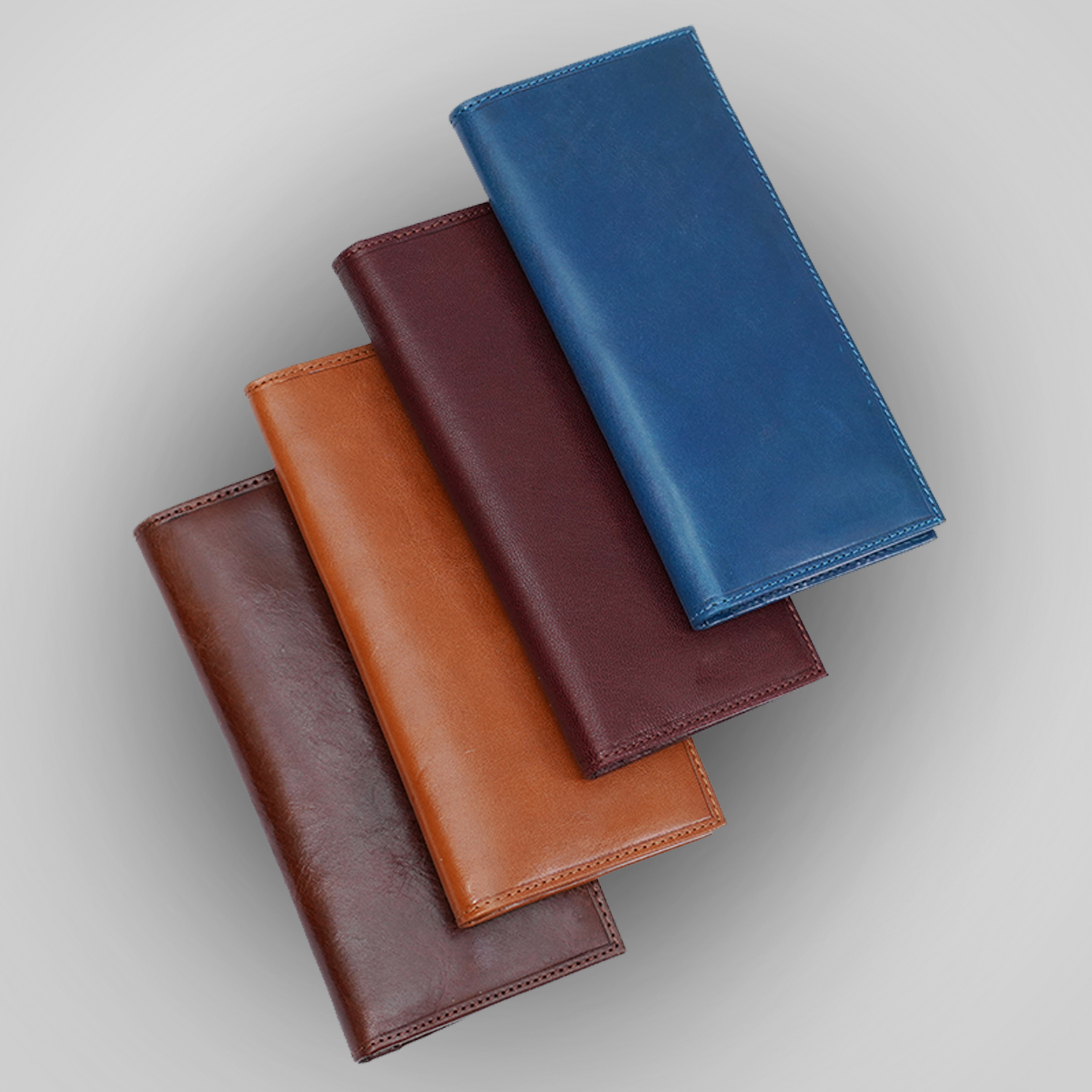 Four leather wallets in brown and blue on a light gray background