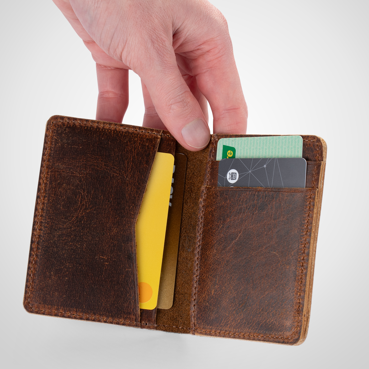 Brown leather card holder wallet with cards on a light gray background