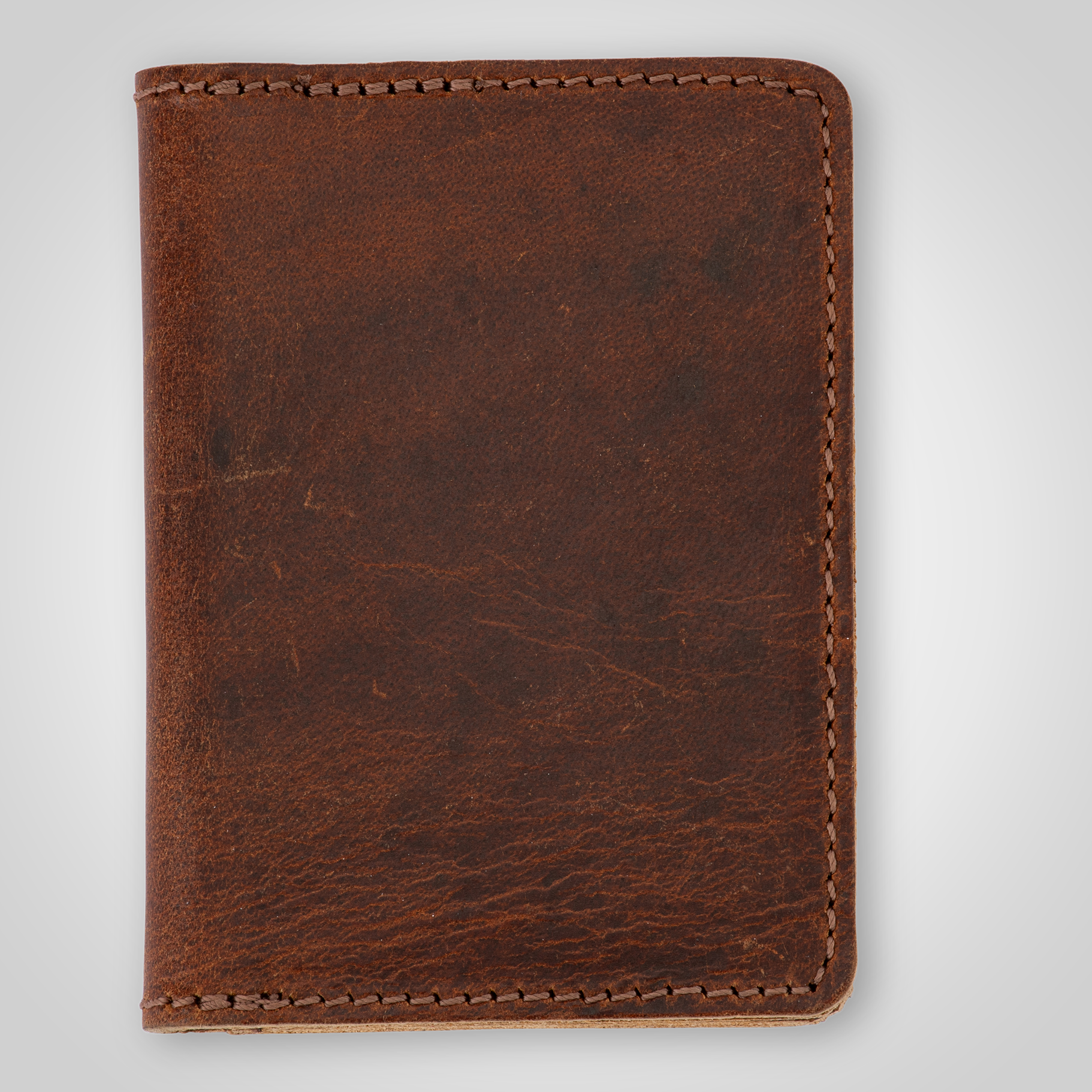 Brown leather card holder on a light gray background
