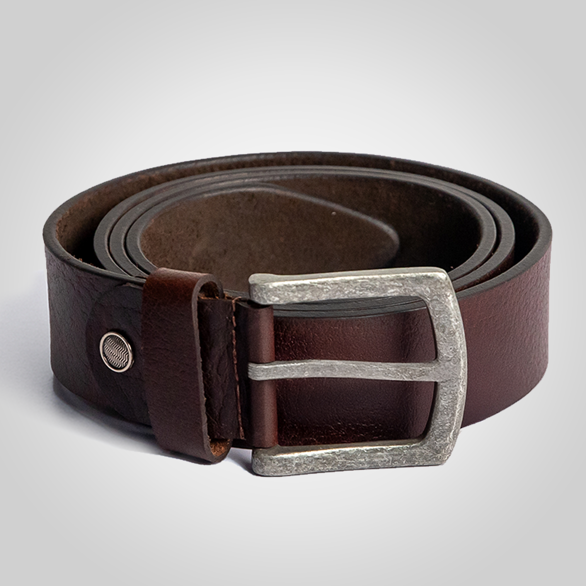 Brown leather belt with silver buckle on a light gray background