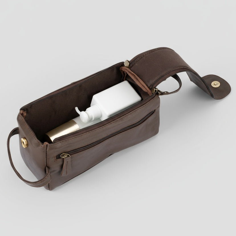 Brown leather pouch with gold hardware on a light gray background