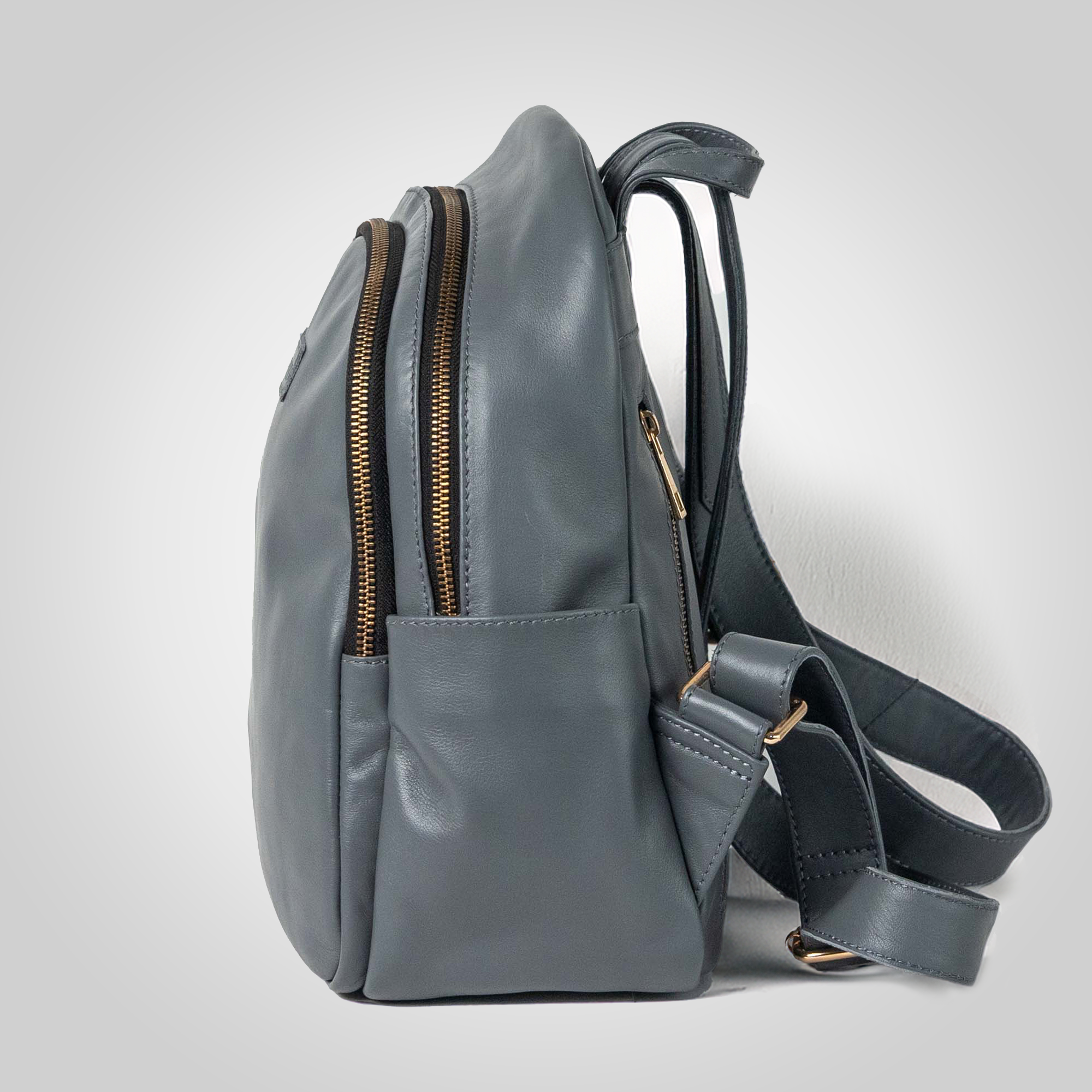 Gray backpack with gold zippers on a light gray background