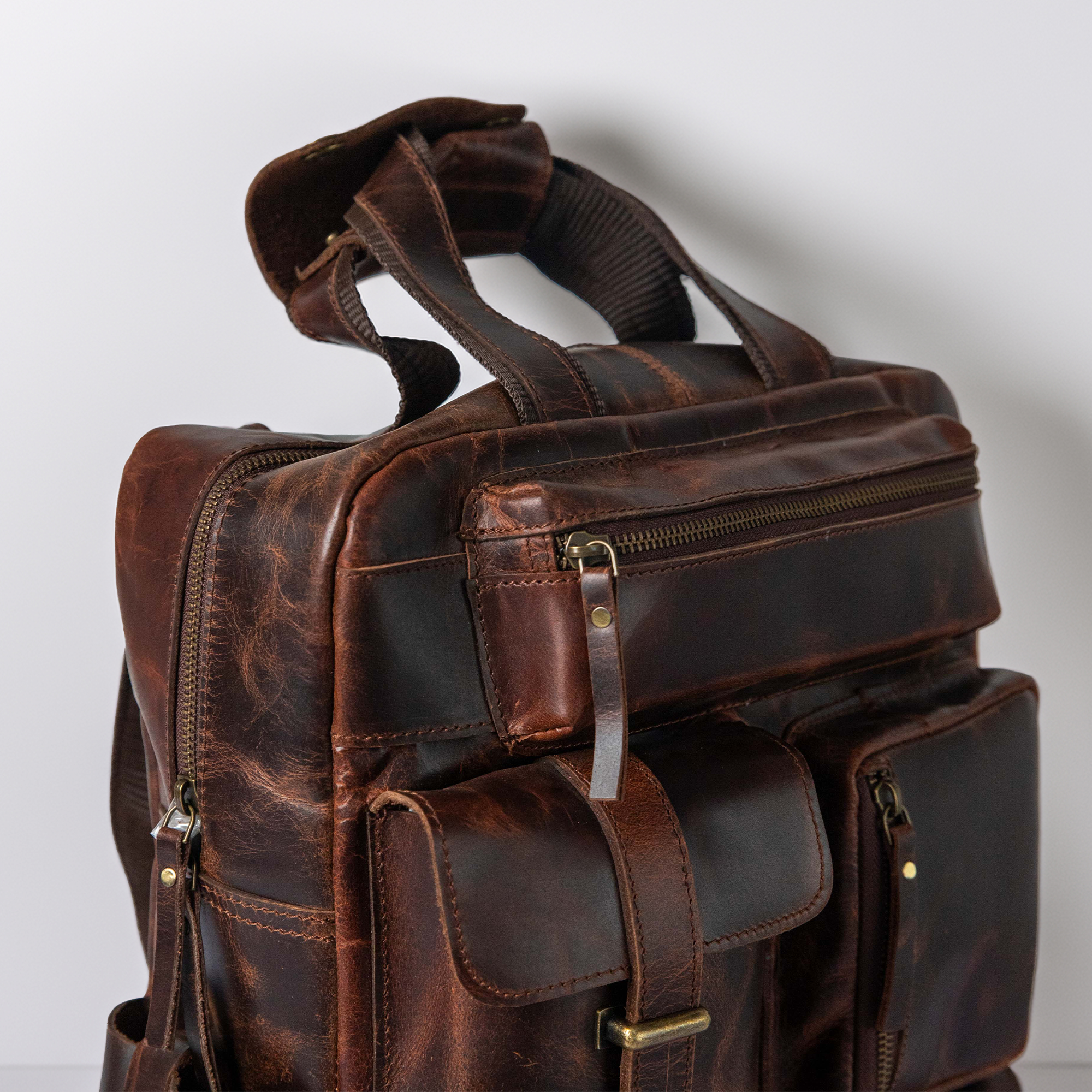 Close-up of The Pathfinder premium full grain leather texture and brass zipper hardware