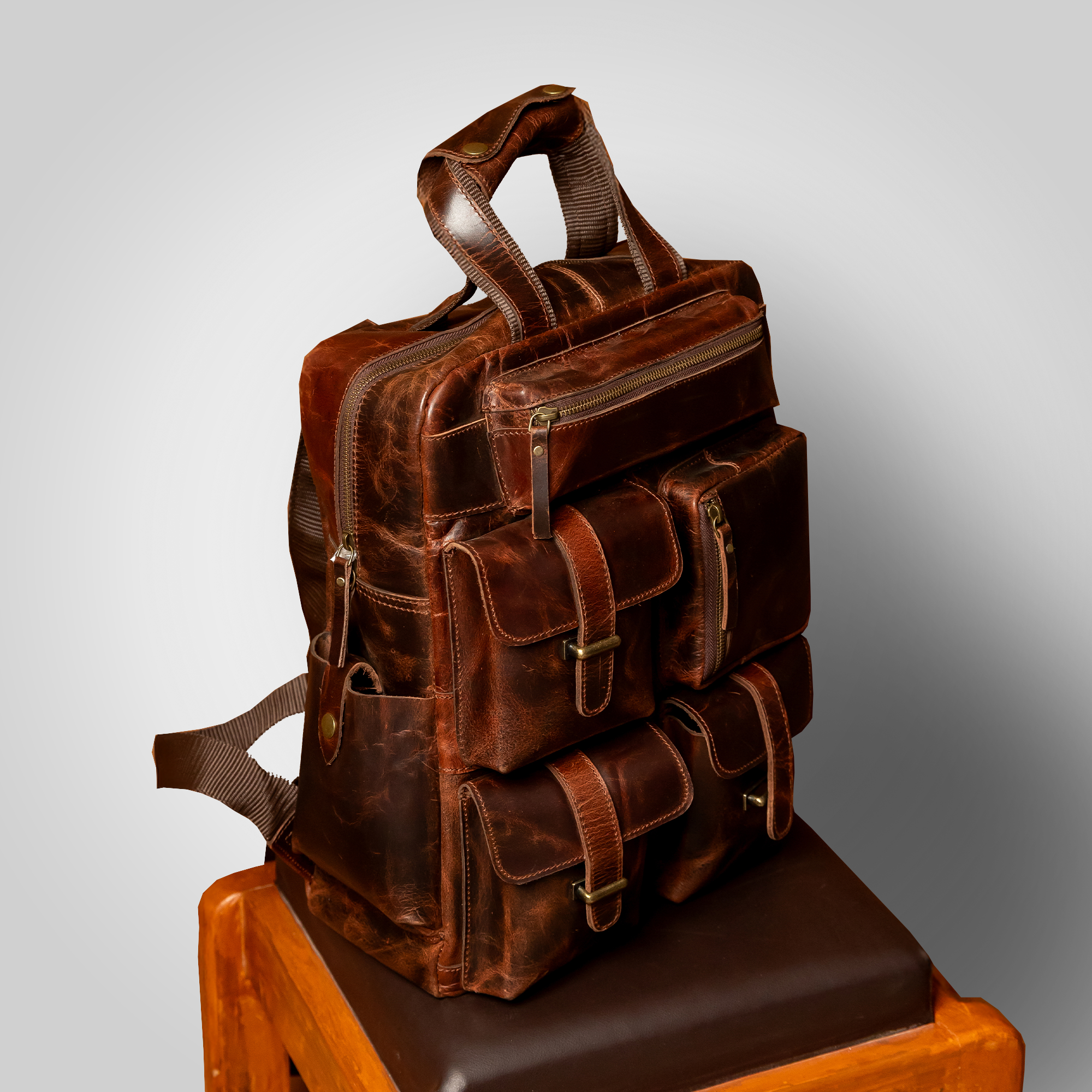 The Pathfinder brown leather backpack placed on table – minimal, modern travel style
